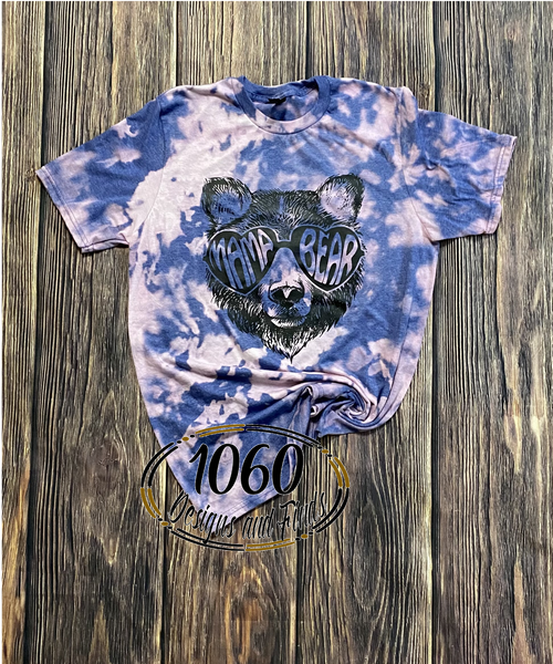 unisex sizing graphic tee with bear wearing mama bear sunglasses. Distressed bleaching with blue and pink coloration. 